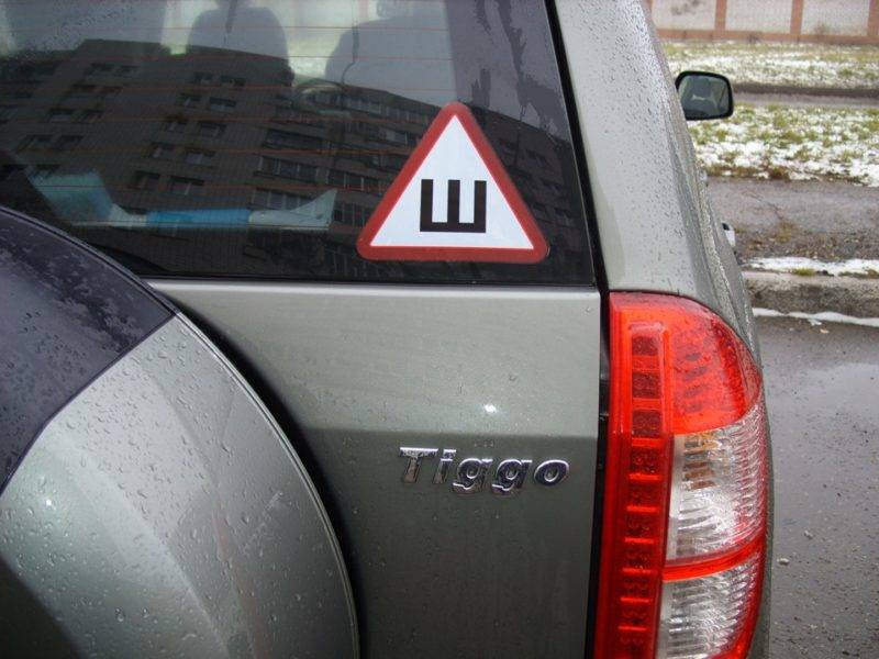 По закону знак должен быть на задней части автомобиля, при этом клеиться вершиной вверх. Наклейка размещается преимущественно на заднем стекле автомобиля.
